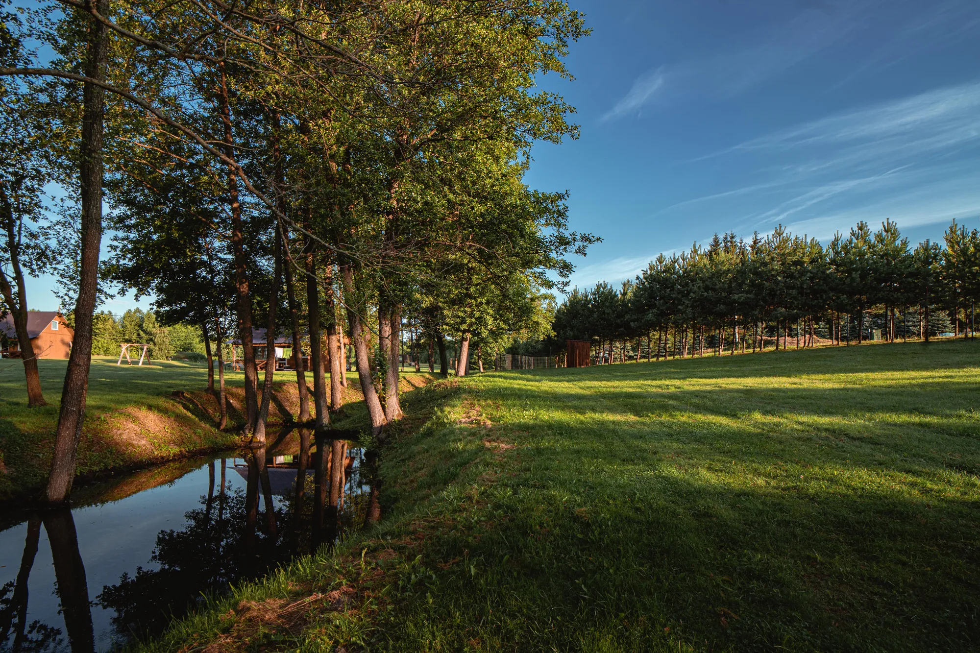 Nameliai naktį — kabiną šiltas apšvietimas iš langų, kelio šviesos, žvaigždytas dangus