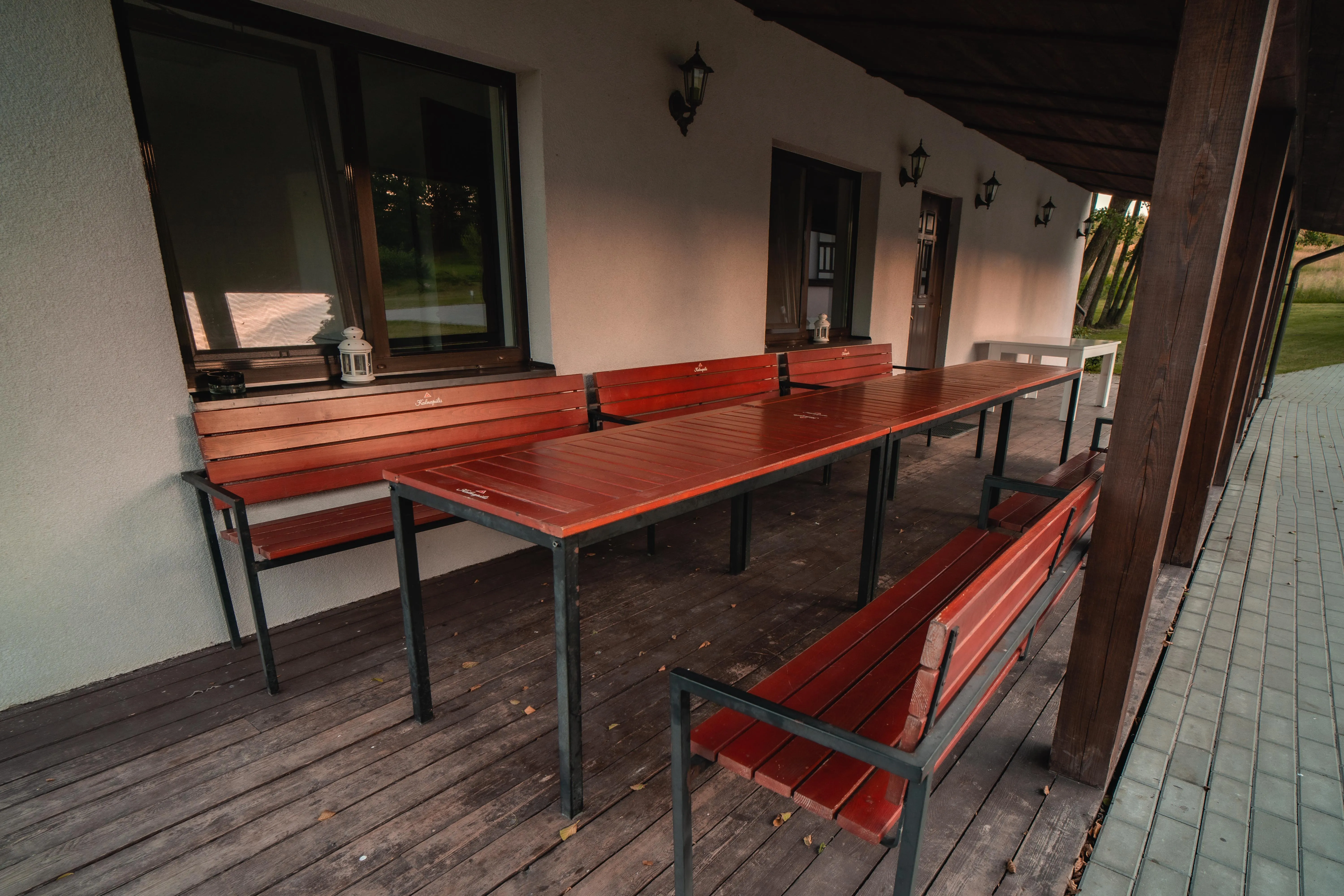 Lauko pietavimo zona — medinis stalas su šildais, gryna gamtą aplinkui